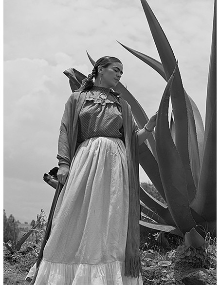 Frida Kahlo de pie junto a una planta de agave